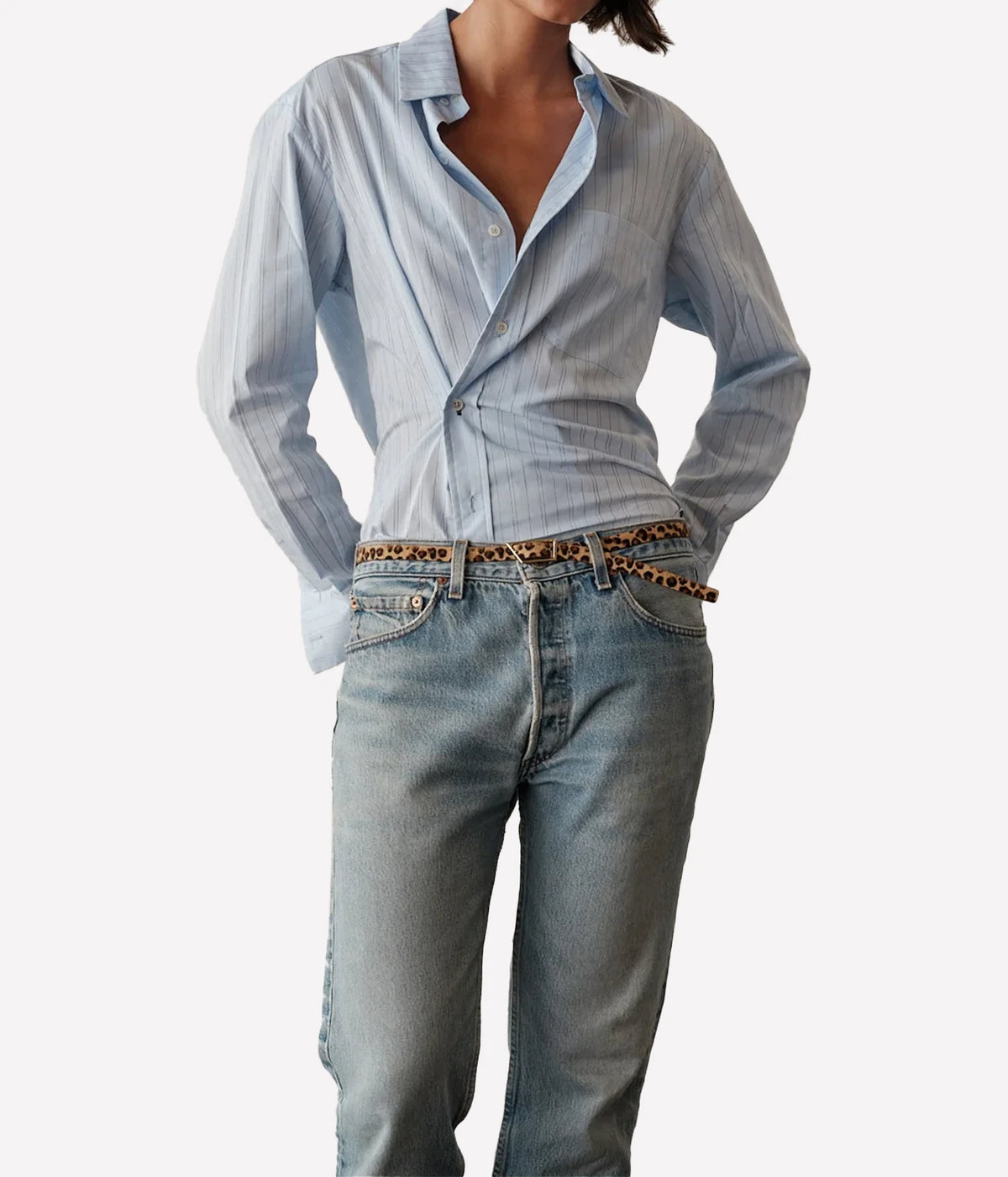 Model wearing the CISSA Daily Shirt in Blue Needle with hands in the pockets of light-wash jeans, showing the open collar and long sleeves