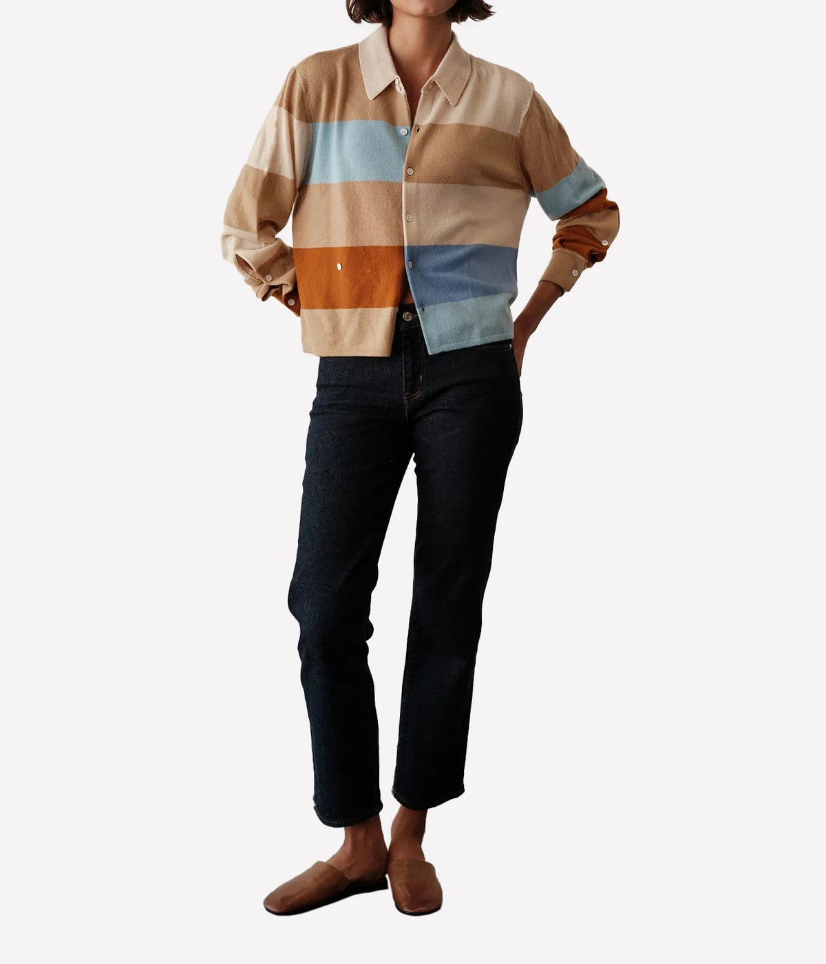 Full-length view of a model wearing the CISSA Rugby Cardigan in Desert Sky with black cropped trousers and brown loafers