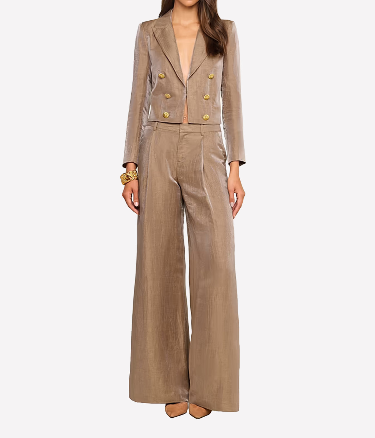 A model wearing a taupe blazer and matching wide-leg trousers with gold buttons.
