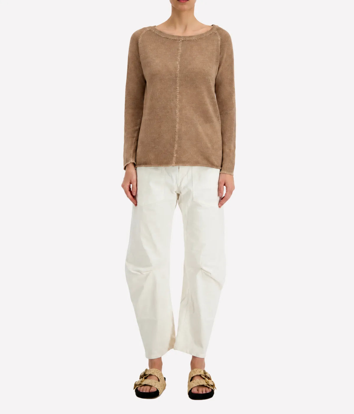 Model wearing the Avant Toi Maglia Pullover in Sughero untucked over cream barrel-leg trousers with dark sandals, showing the raglan sleeves and relaxed fit