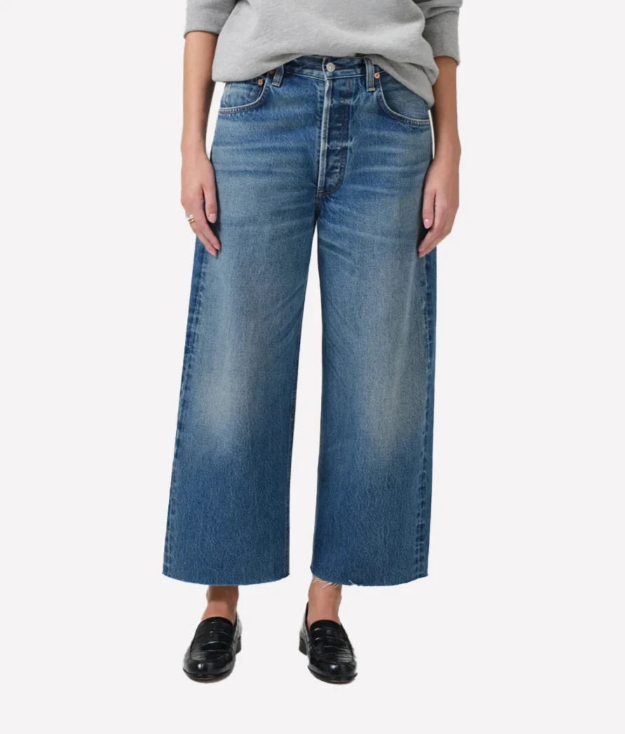 Ayla Raw Hem Crop Jean in medium indigo, featuring a relaxed rise, easy leg, and cropped inseam with fading and whiskering, crafted from 100% regenerative cotton.