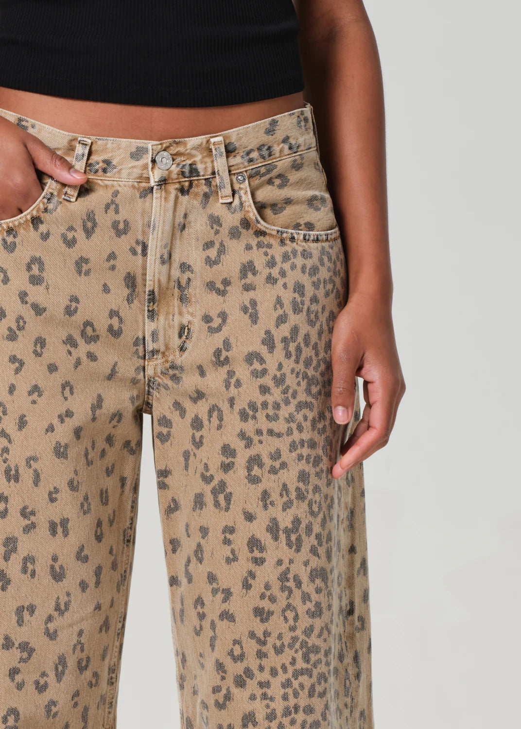 ALT text: Light beige denim jeans with cheetah print, styled with a simple tee.