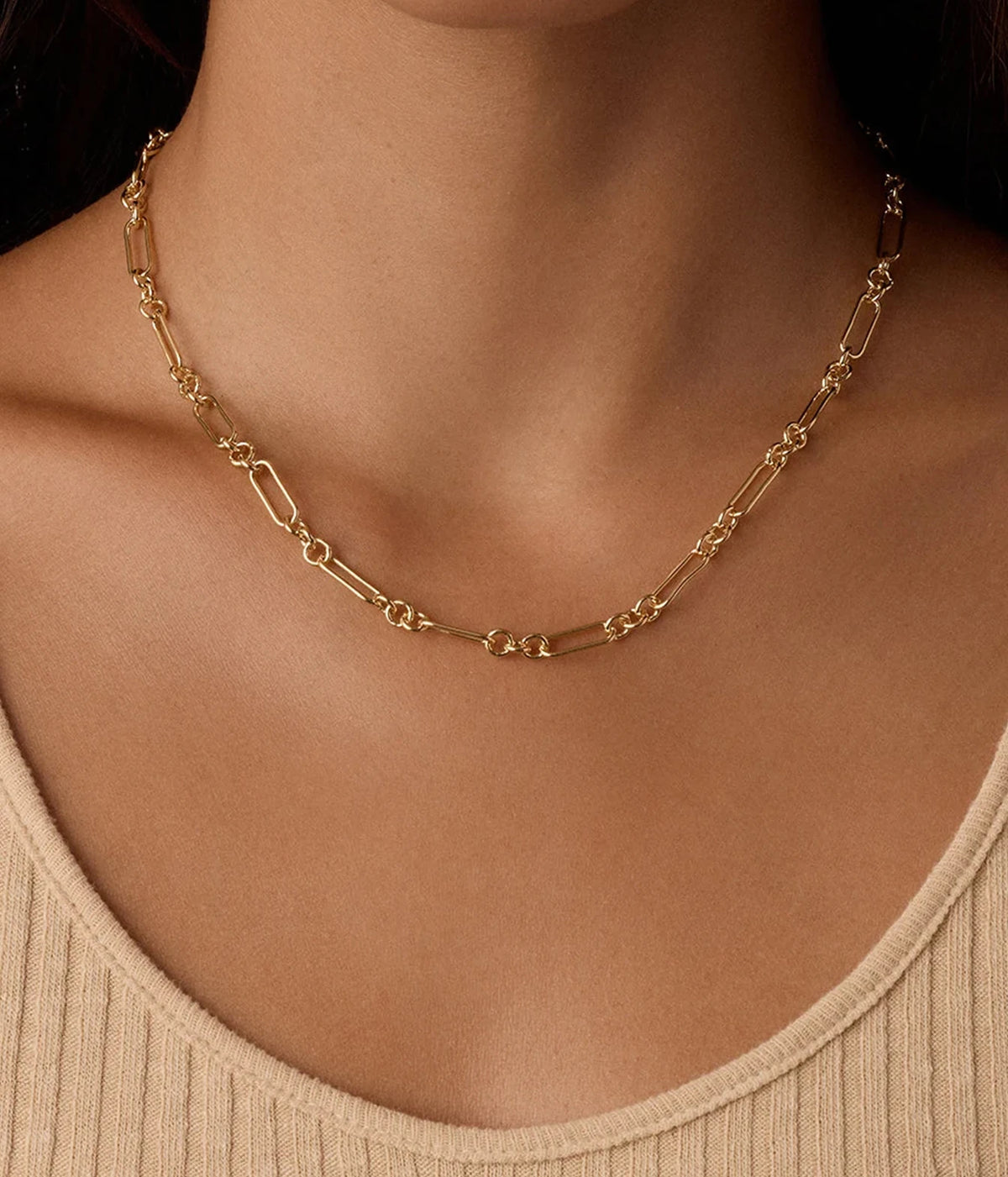 Close-up of a model wearing the Gorjana Reed Link Necklace in Yellow Gold with a beige ribbed knit top, showing where the chain sits on the collarbone