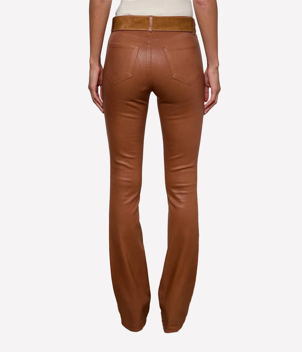 A back view of a model wearing the L'AGENCE Selma Coated Bootcut Jean in Cognac and a white top with a tan belt