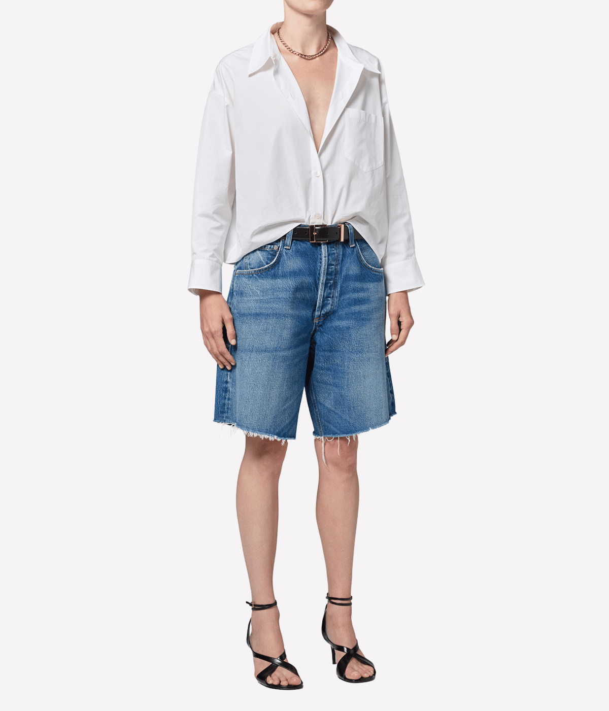 Front view of a model wearing the Citizens of Humanity Ayla Short in Chaya with a white button-up shirt tucked in, a black leather belt, a delicate gold necklace and black strappy heeled sandals