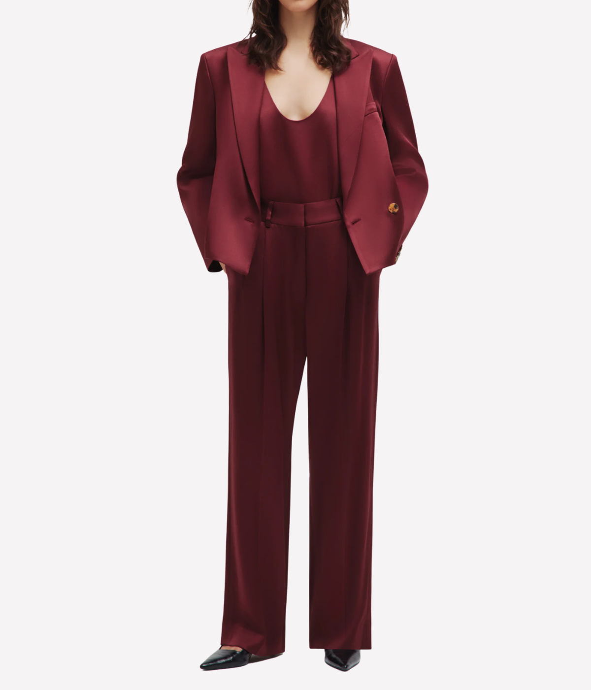 A model wearing a matching burgundy three-piece suit set consisting of a structured blazer, a deep V-neck top, and wide-leg trousers - Novalis Fox Pants Pant In Wine