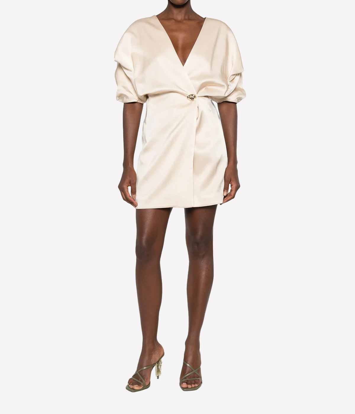 Front view of a model wearing the Raquel Diniz Anastasia Short Dress in Vanilla with strappy heeled sandals, showing the wrap V-neckline and mini length