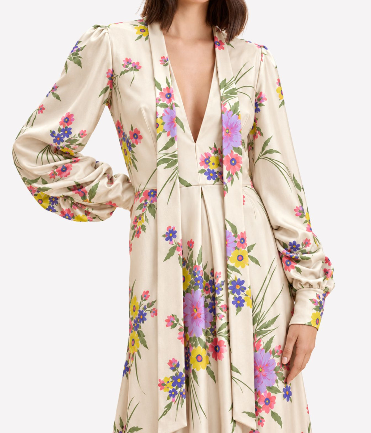 Close-up of a model wearing the Raquel Diniz Valerie Dress in Pink Floral, showing the deep V-neckline, voluminous gathered sleeves and fitted waist