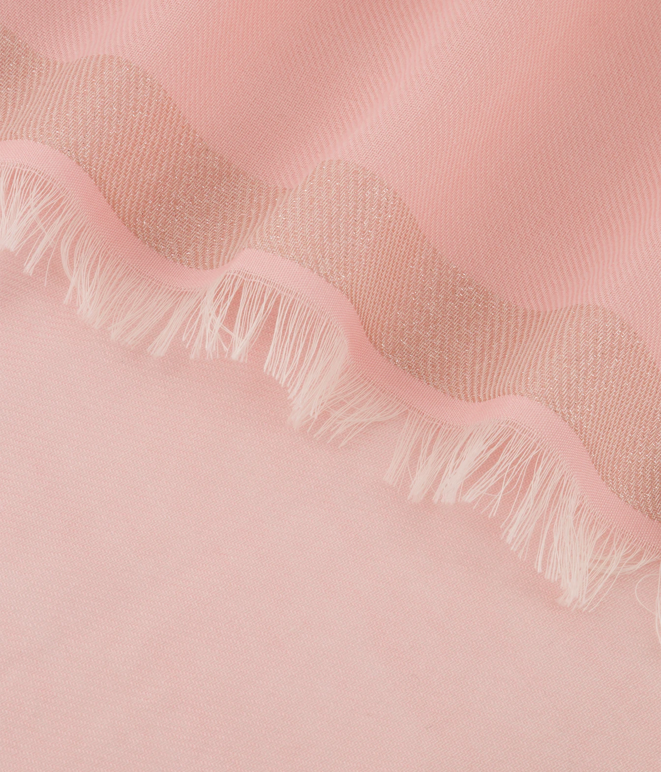 A close-up of a soft pink fabric with a scalloped edge and white fringe.