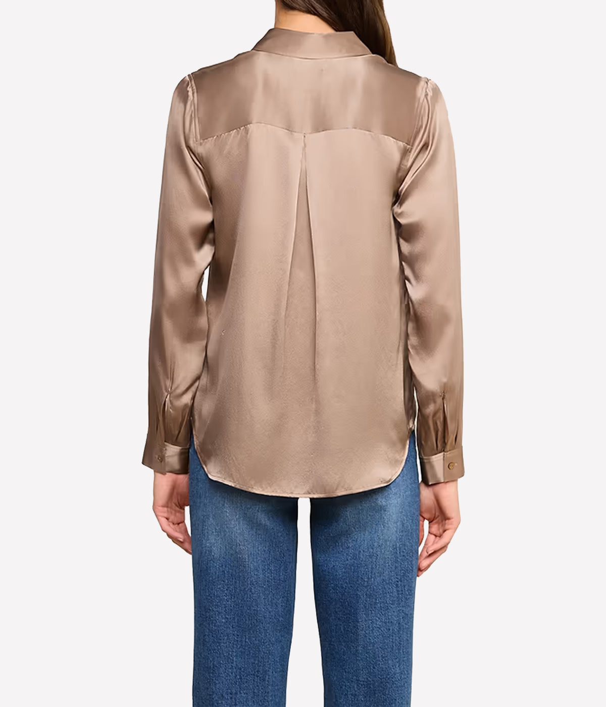 A woman viewed from the back wearing a long-sleeve silk blouse in a warm taupe colour, paired with blue jeans.