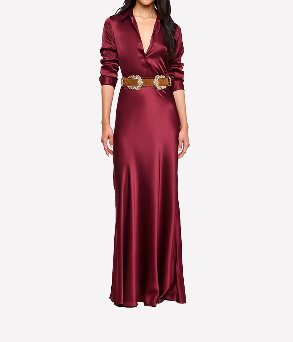 A woman wearing the L'AGENCE Tyler Silk Blouse in Merlot Red, styled with a brown suede belt and matching silk maxi skirt in red