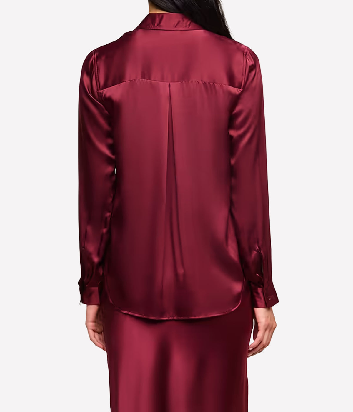 A person shown from the back wearing the L'AGENCE Tyler Silk Blouse in Merlot Red and matching skirt in a merlot red.
