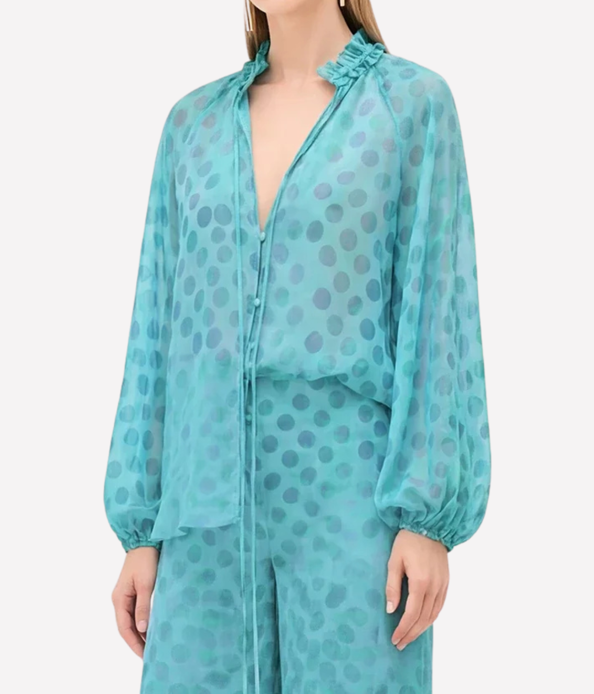 Teal polka dot dress with long sleeves on a white background