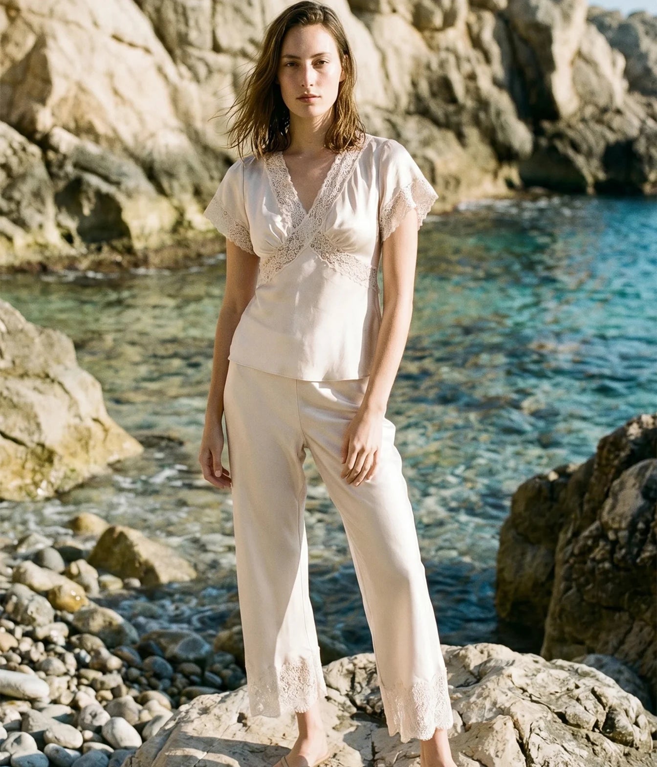 A model wearing a light cream two-piece set with a lace-trimmed short-sleeve top