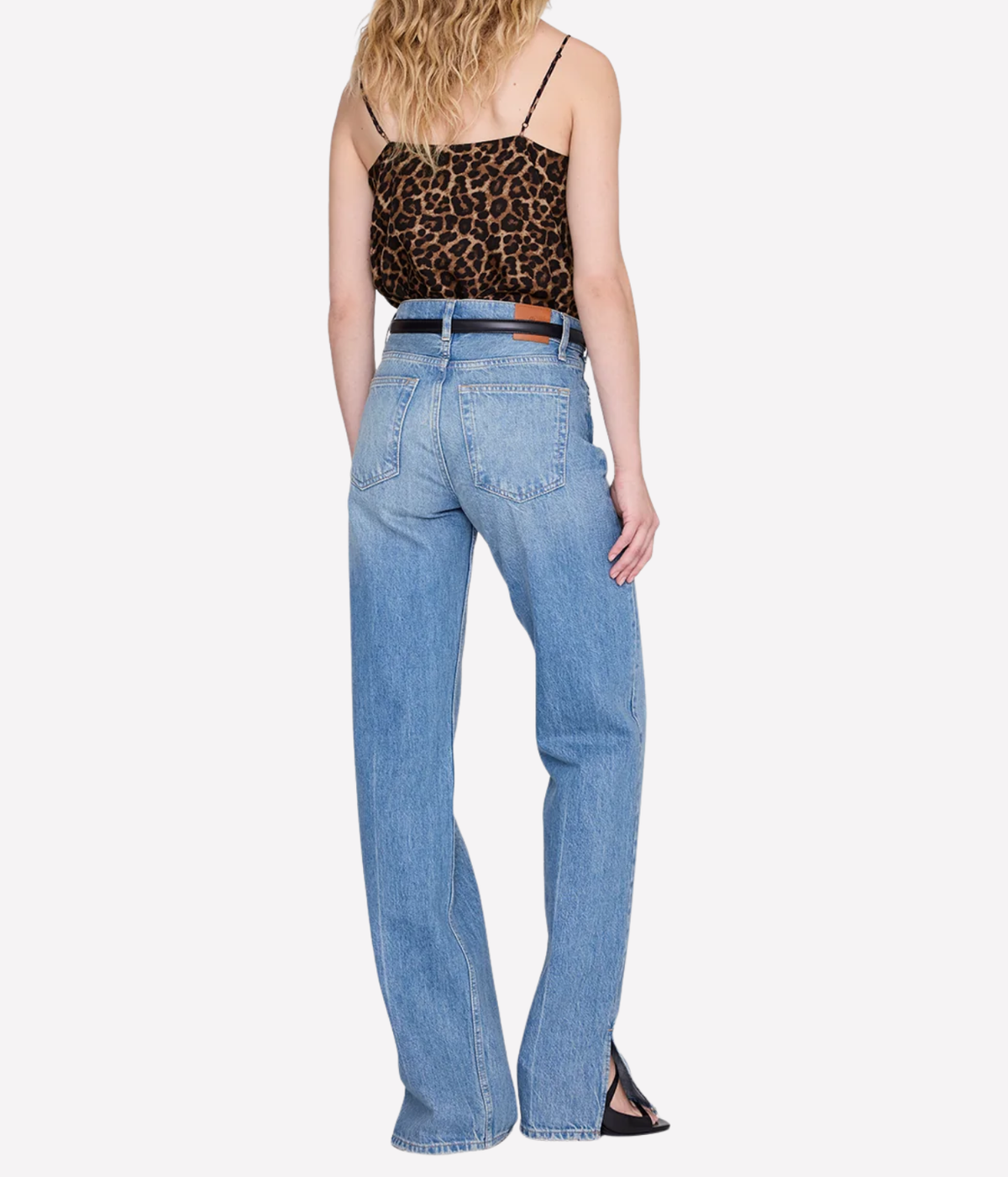 A model shown from the back wearing light-wash blue jeans, a leopard-print camisole, and a brown belt against a plain white background.
