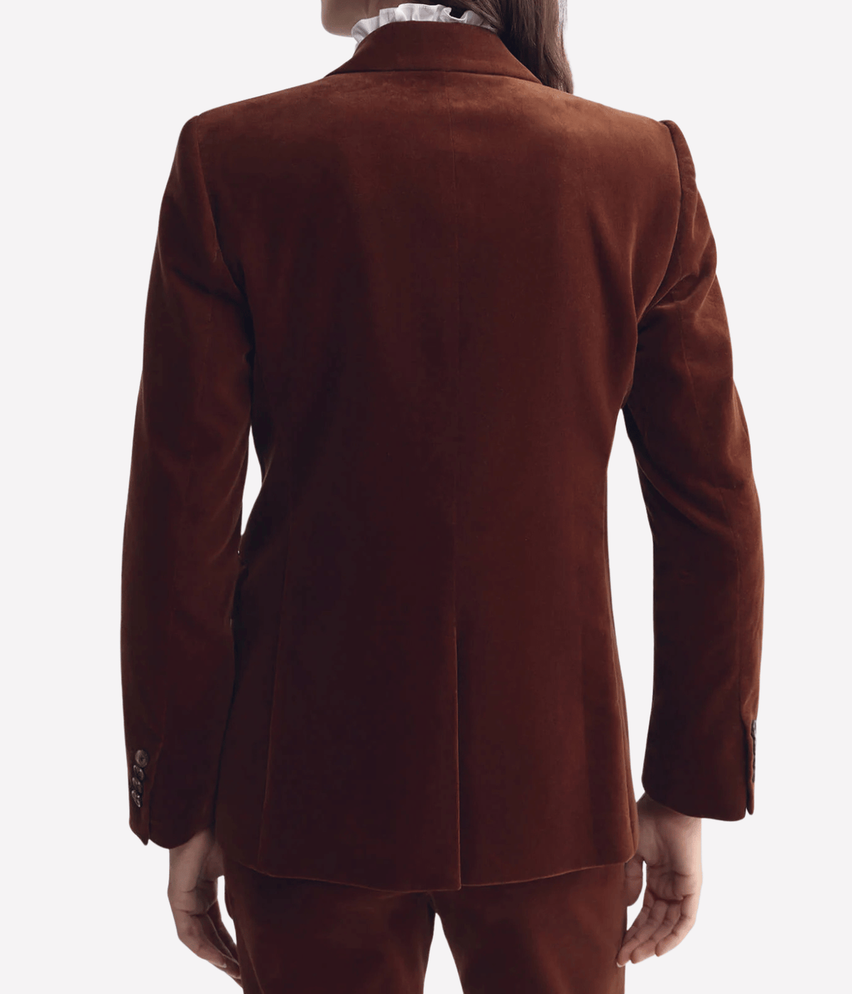 Back view of a model wearing the Nili Lotan Anabel Tailored Jacket in Burnt Sienna with matching trousers, showing the shaped back and hip length