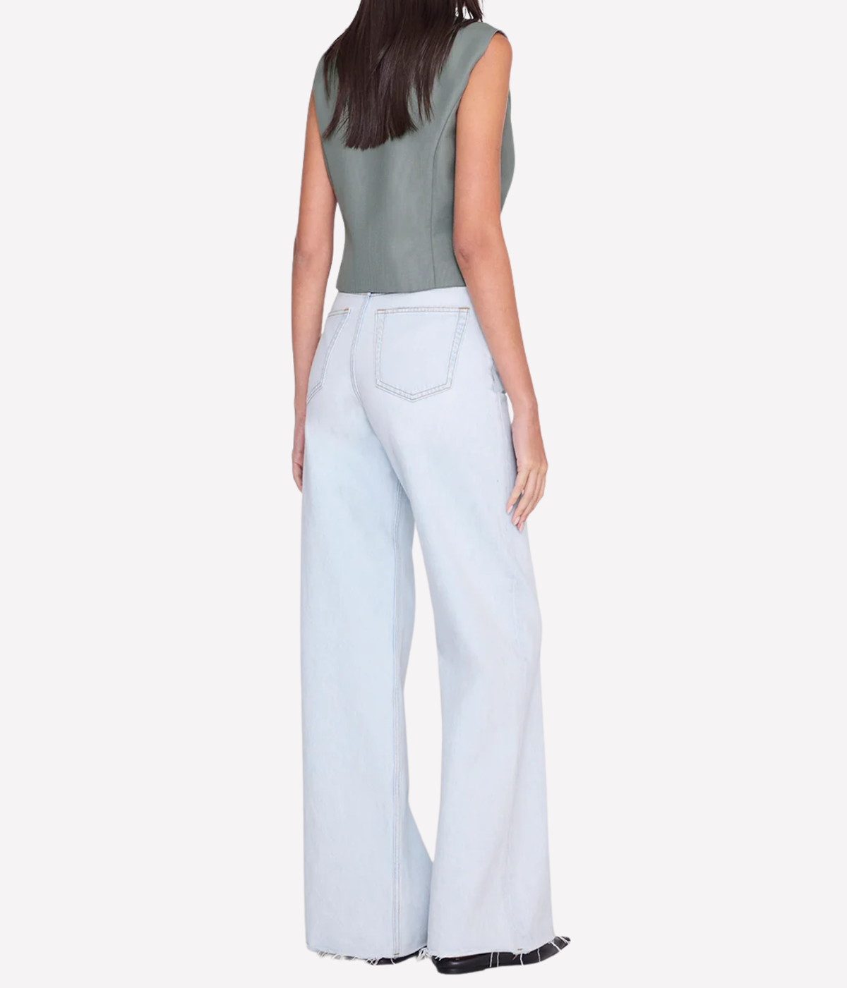 Back view of a model wearing the Anine Bing Mario Vest in Sage with light-wash wide-leg jeans and black pointed shoes