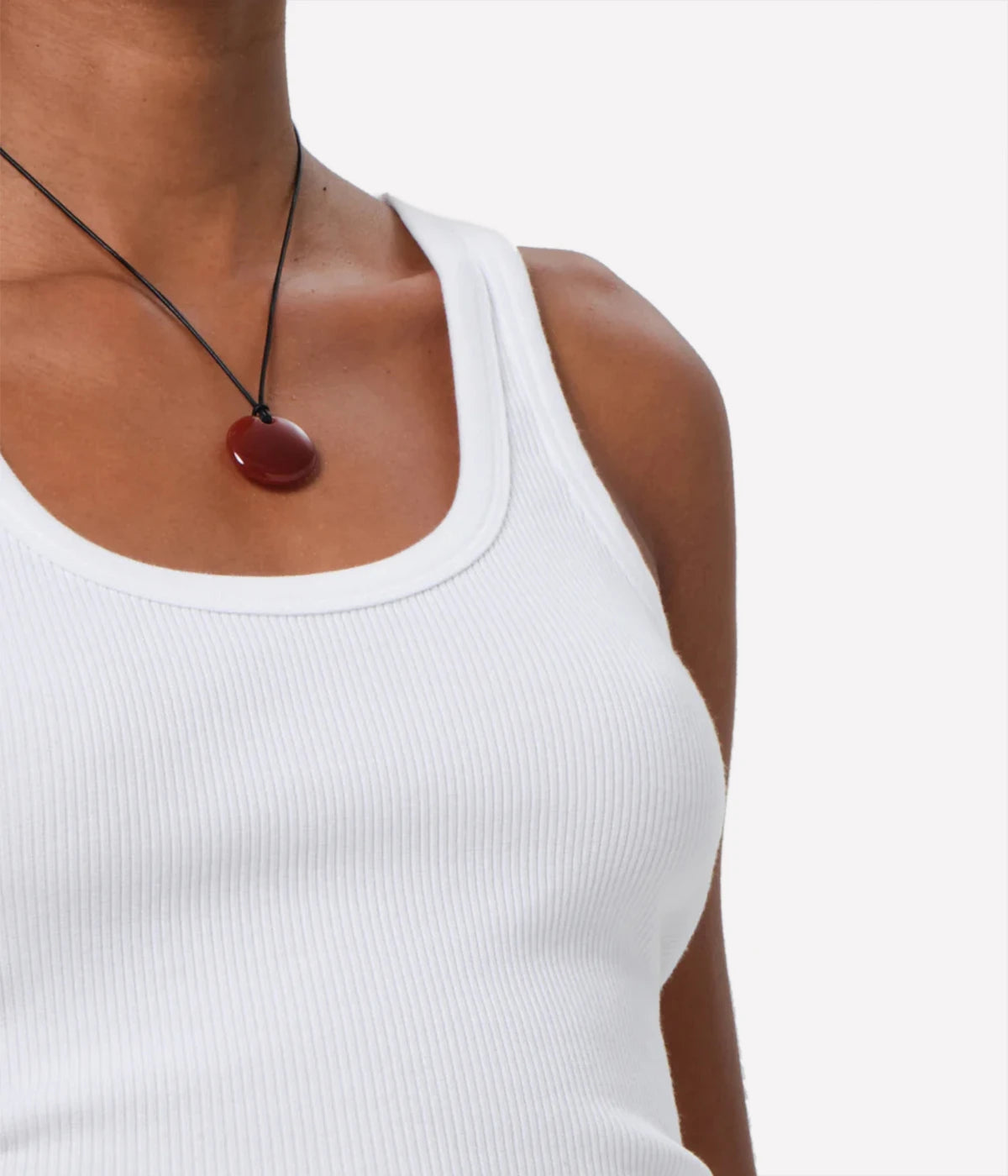 ALT text: White scoop neck ribbed tank top, styled with high-waisted jeans.