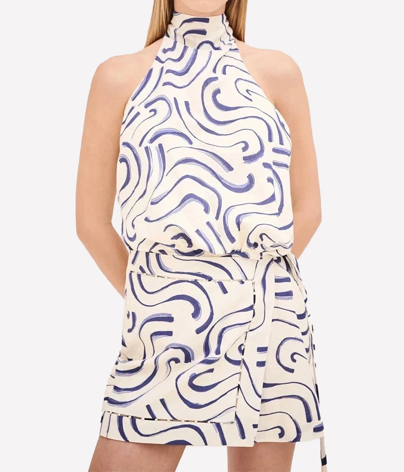 A sleeveless halter-neck wrap dress with a high-waisted tie belt, featuring an abstract wavy line pattern in navy blue on an off-white background.