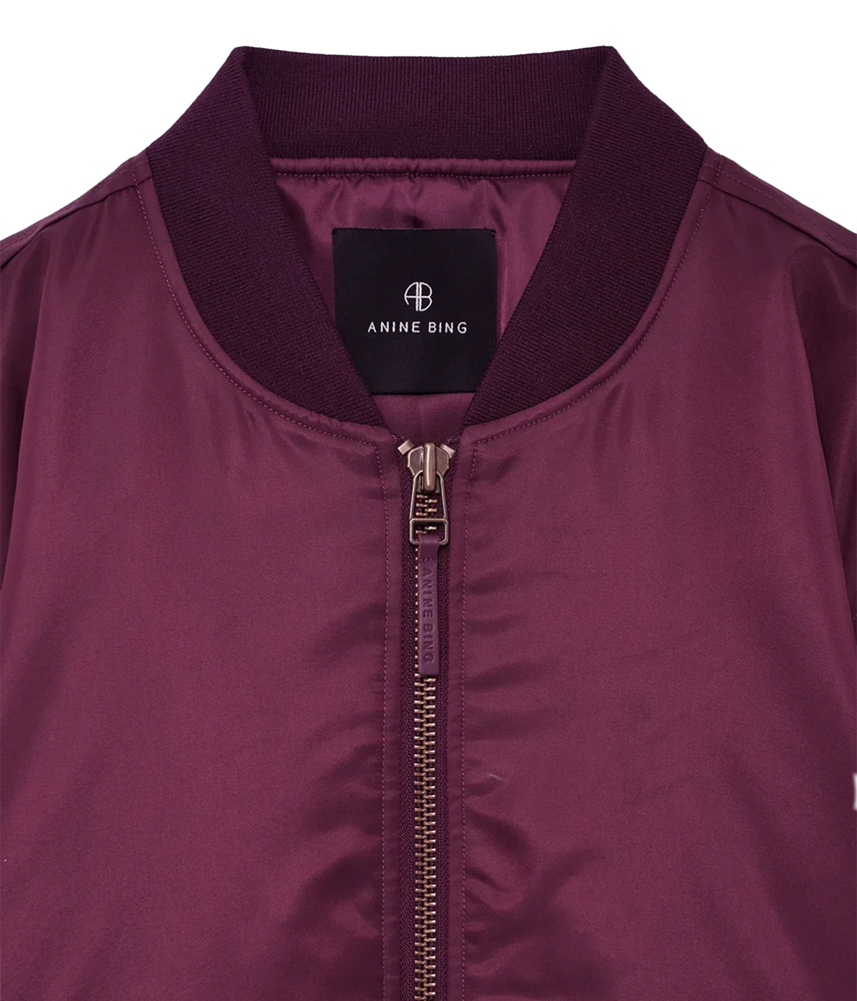 Close-up of a women's bomber jacket in deep burgundy, featuring a ribbed knit collar, a front zipper, and a black Anine Bing brand label.