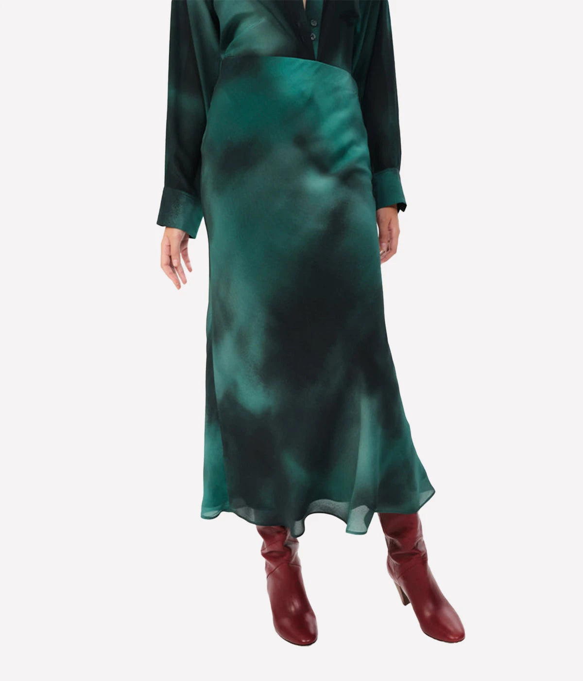 A flowing 100% silk midi skirt in a vibrant, refined hue, styled with a cashmere sweater and ankle boots for a chic look.