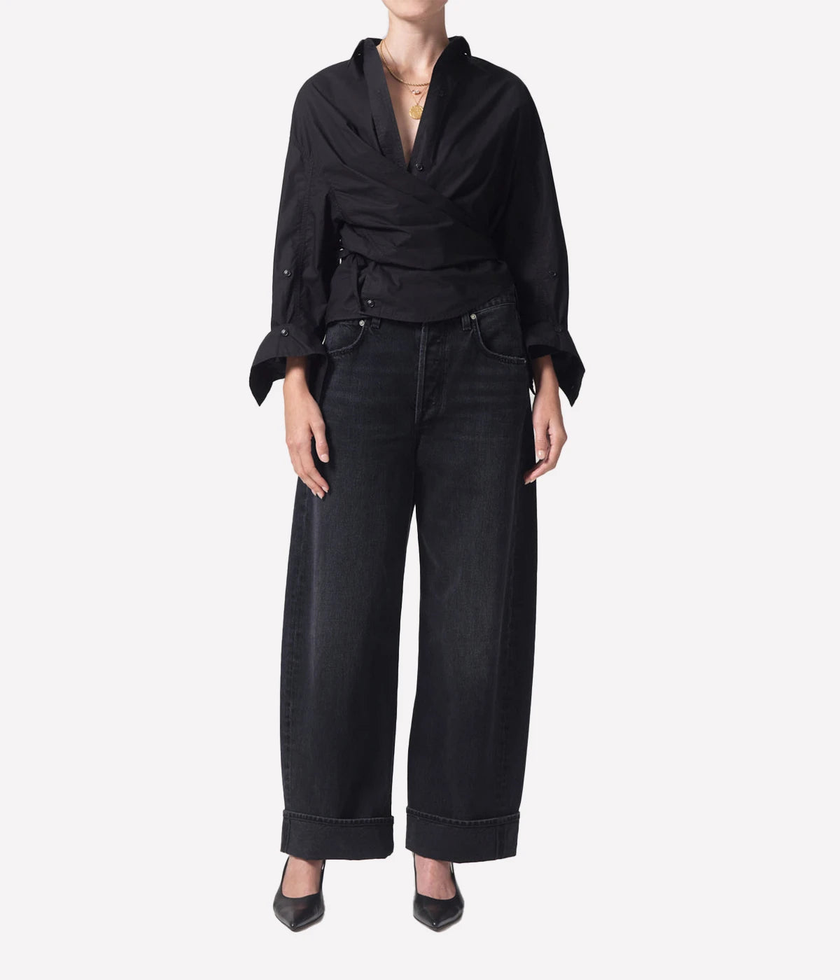 High-rise relaxed jeans with untacked cuffs, styled casually with a tucked-in tee and sandals.