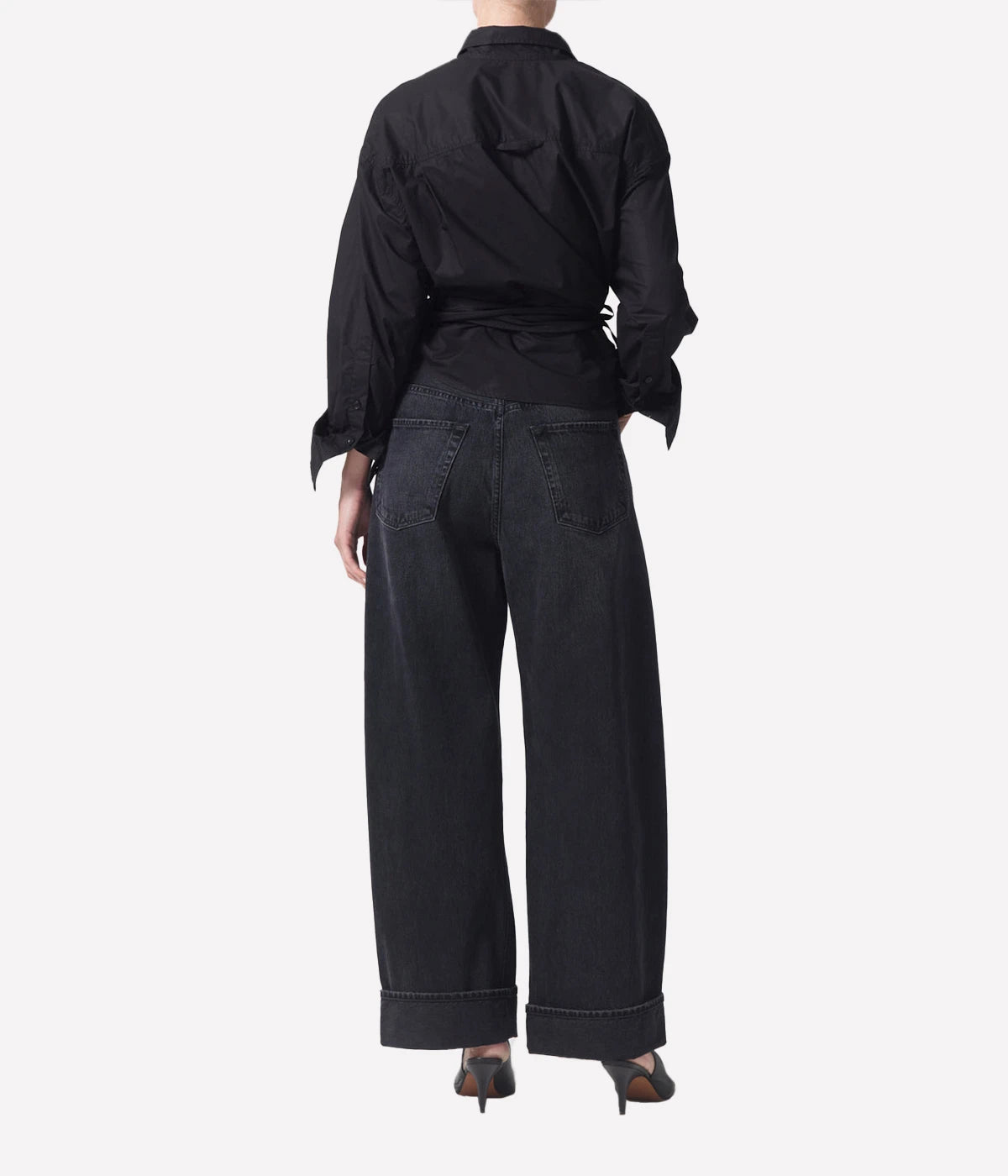 High-rise relaxed jeans with untacked cuffs, styled casually with a tucked-in tee and sandals.