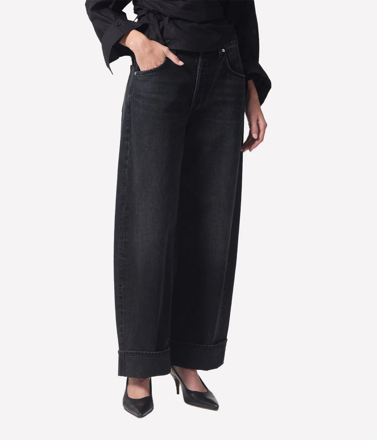 High-rise relaxed jeans with untacked cuffs, styled casually with a tucked-in tee and sandals.