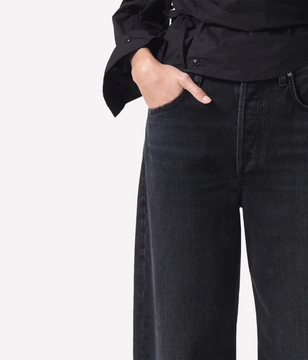 High-rise relaxed jeans with untacked cuffs, styled casually with a tucked-in tee and sandals.