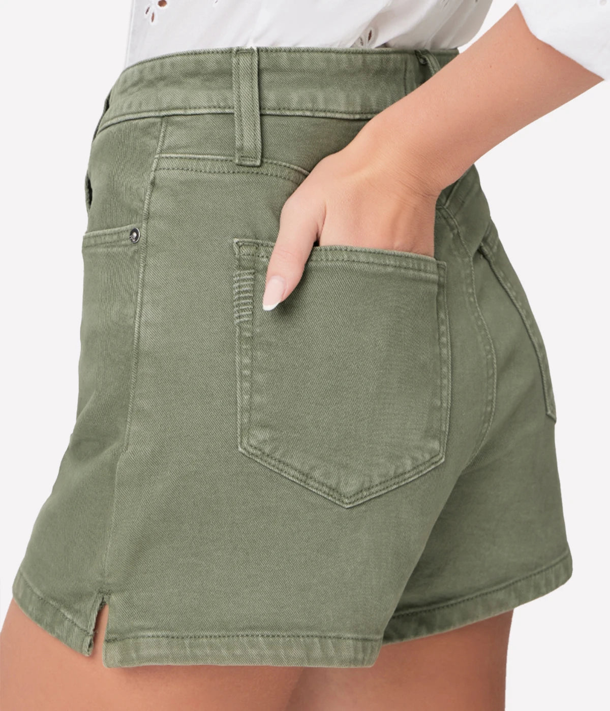 High-rise A-line shorts in vintage ivy green with silver hardware, styled with a white blouse and espadrilles for a relaxed yet chic look.