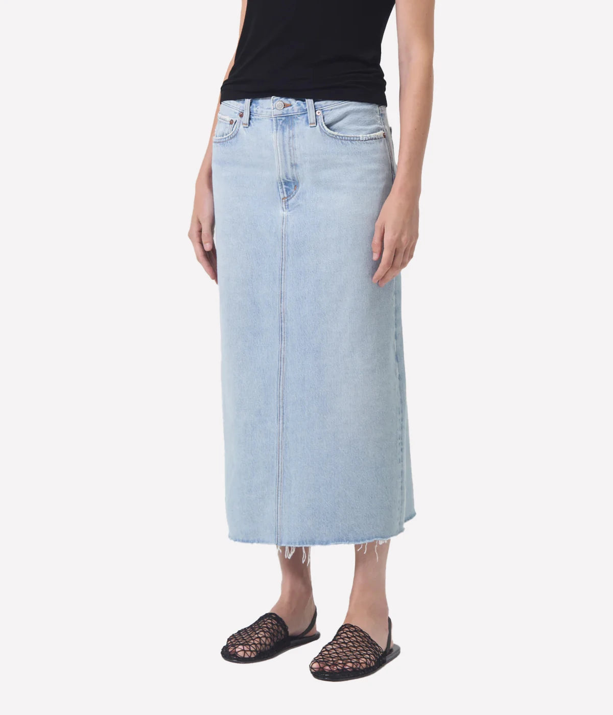 ALT Text: Della Skirt in light-washed indigo denim with raw hem, designed for ankle-grazing length and modern style.