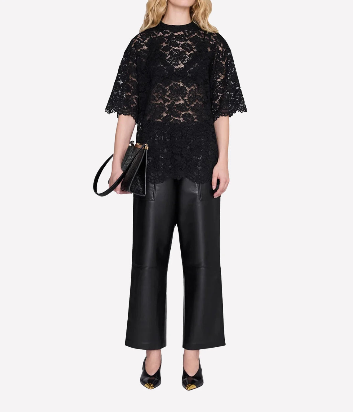 Model wearing the Anine Bing Zeina Top in Black Lace with black wide-leg trousers and heels, shown from the front.