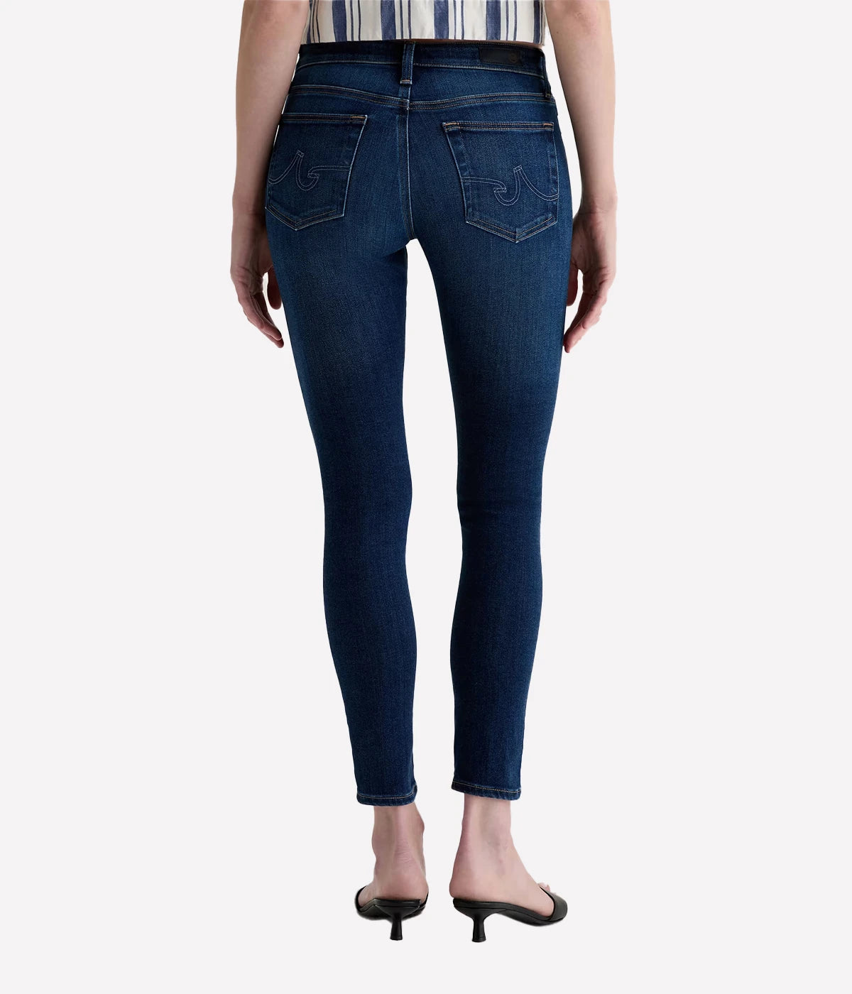 Person wearing dark blue jeans on a white background