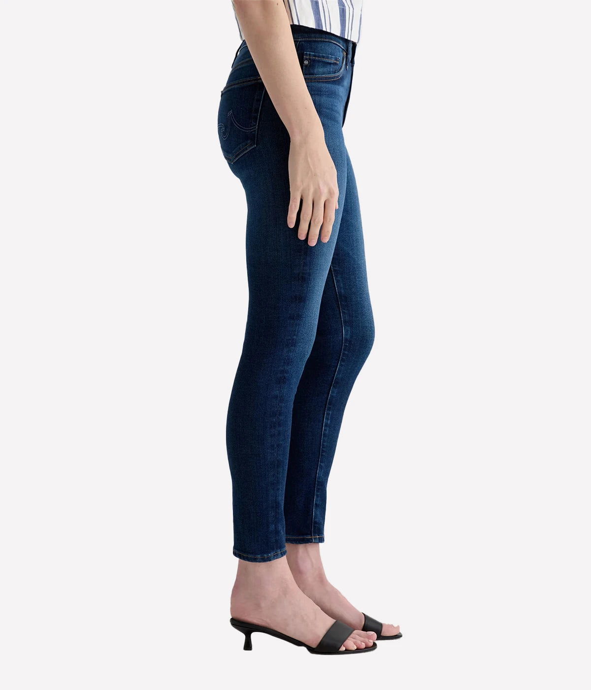 Person wearing dark blue jeans on a white background