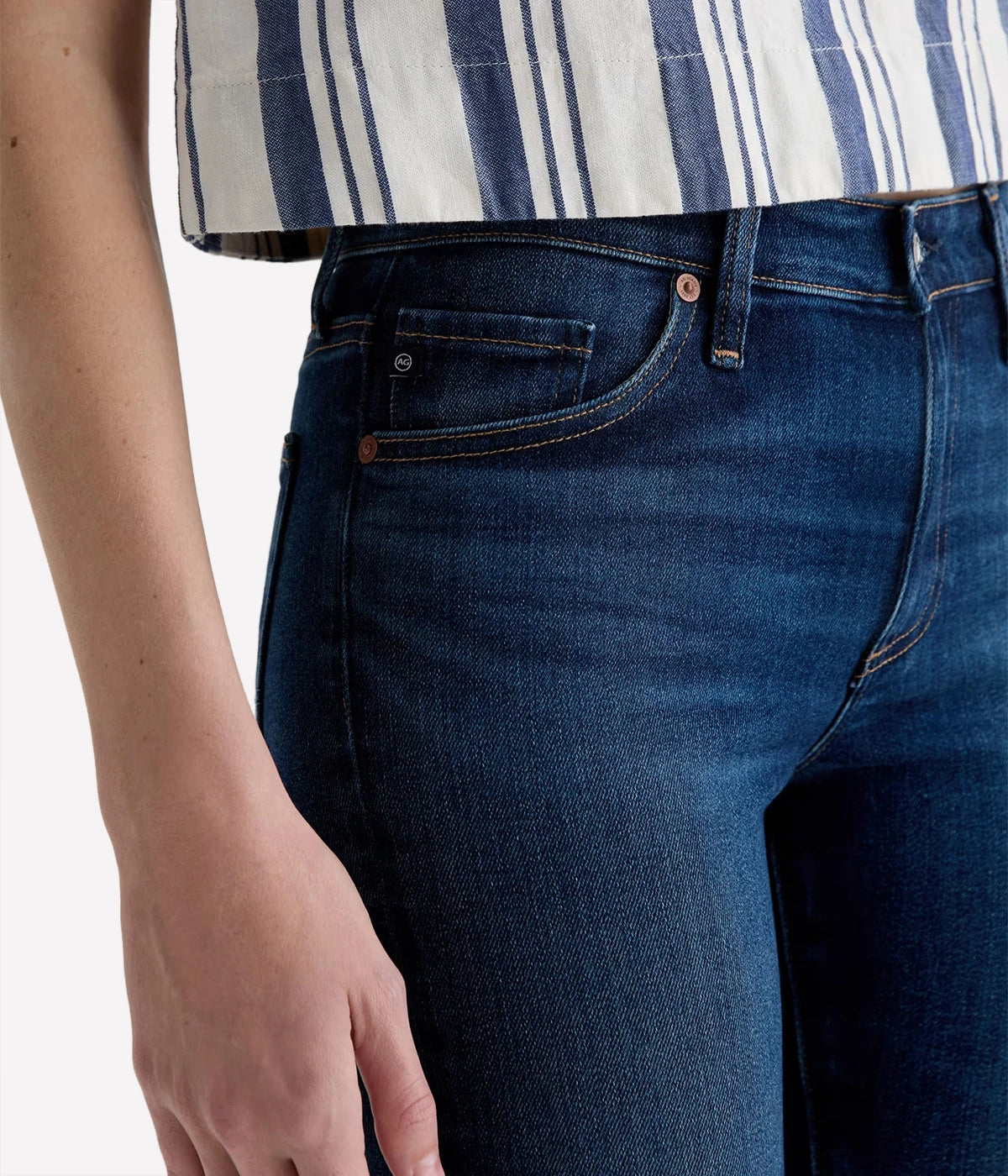 Person wearing blue jeans and a striped shirt on a white background