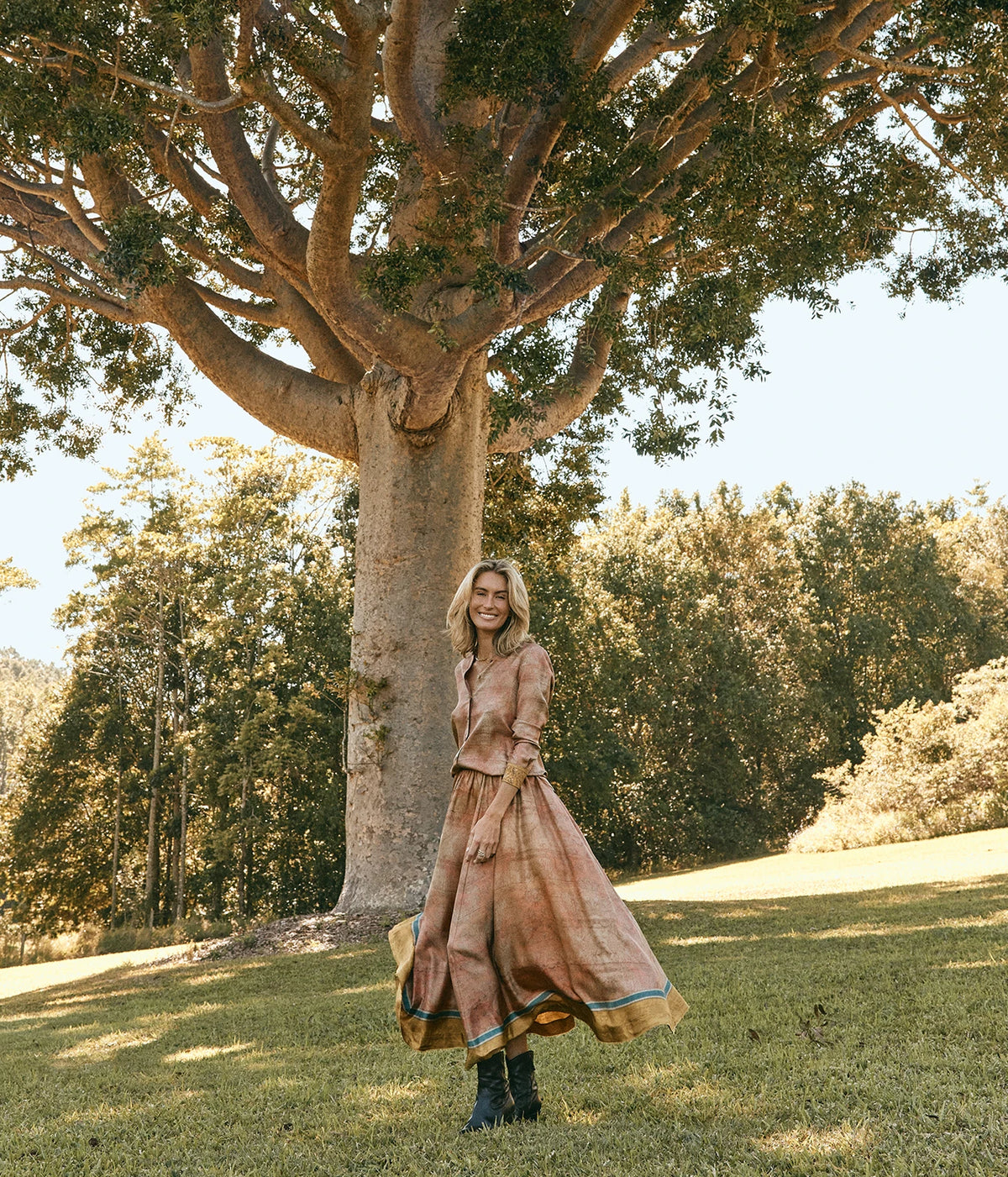Pierre-Louis Mascia Aloe Silk Skirt in Terracotta Multi, full-length view on model with the matching Aloe Shirt, showing the midi length under a large tree