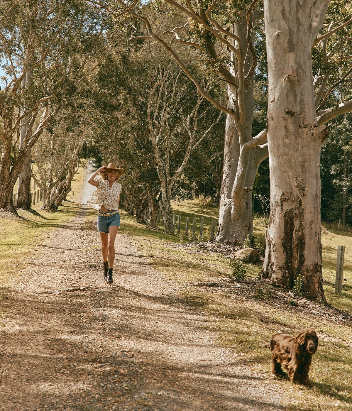 DÔEN Millie Top In Narcissus Bloom, worn on model with denim shorts, walking along a country track with a spaniel