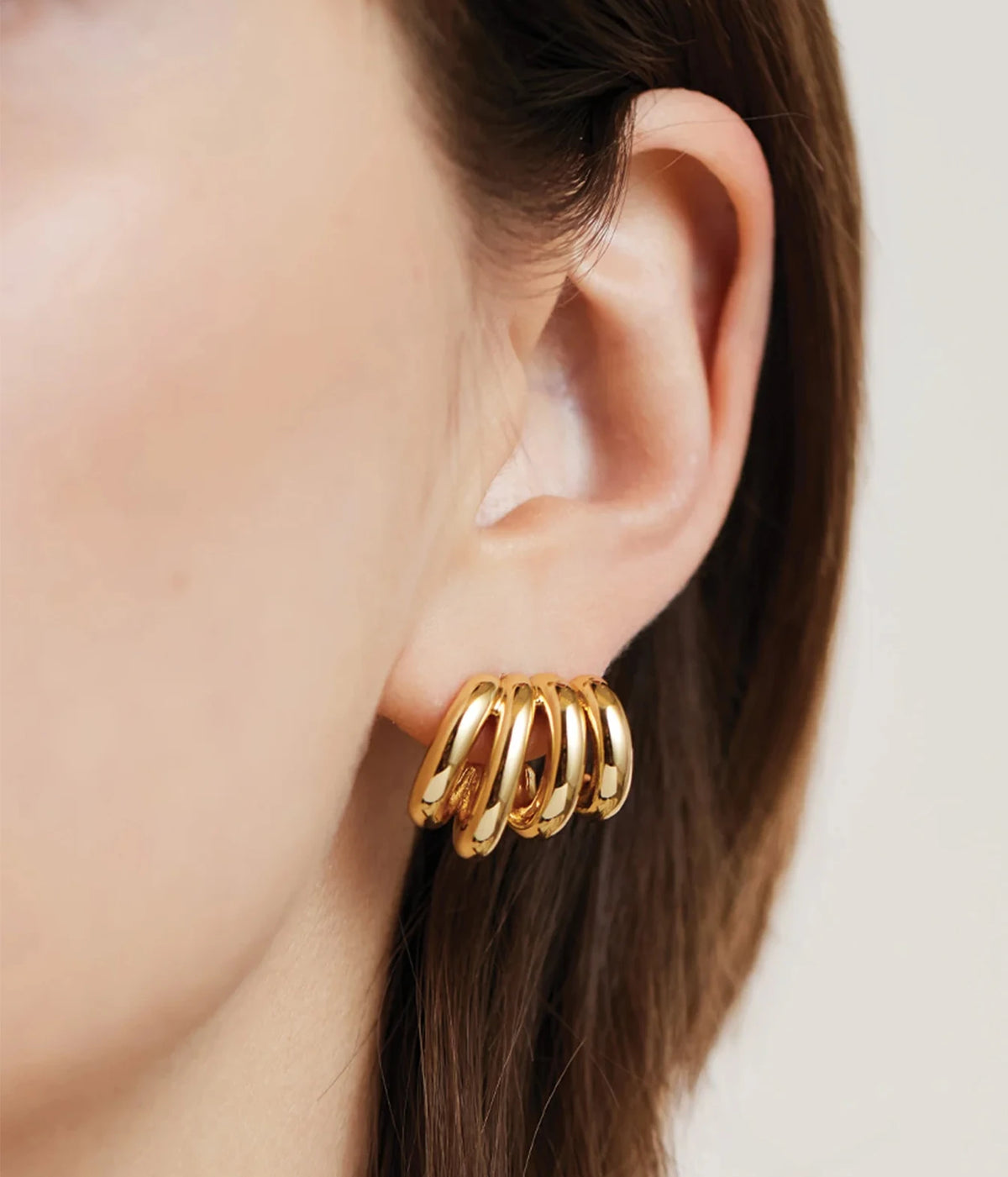 Close-up side profile of a model's ear wearing the Jenny Bird Monroe Earrings in Gold