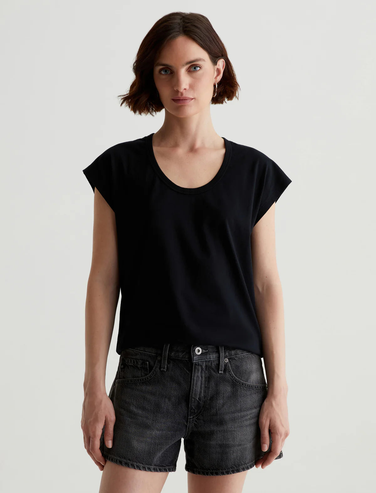 Black Scoopneck AG T-shirt featuring a classic scoop neckline and soft fabric, styled casually with denim for a relaxed look.