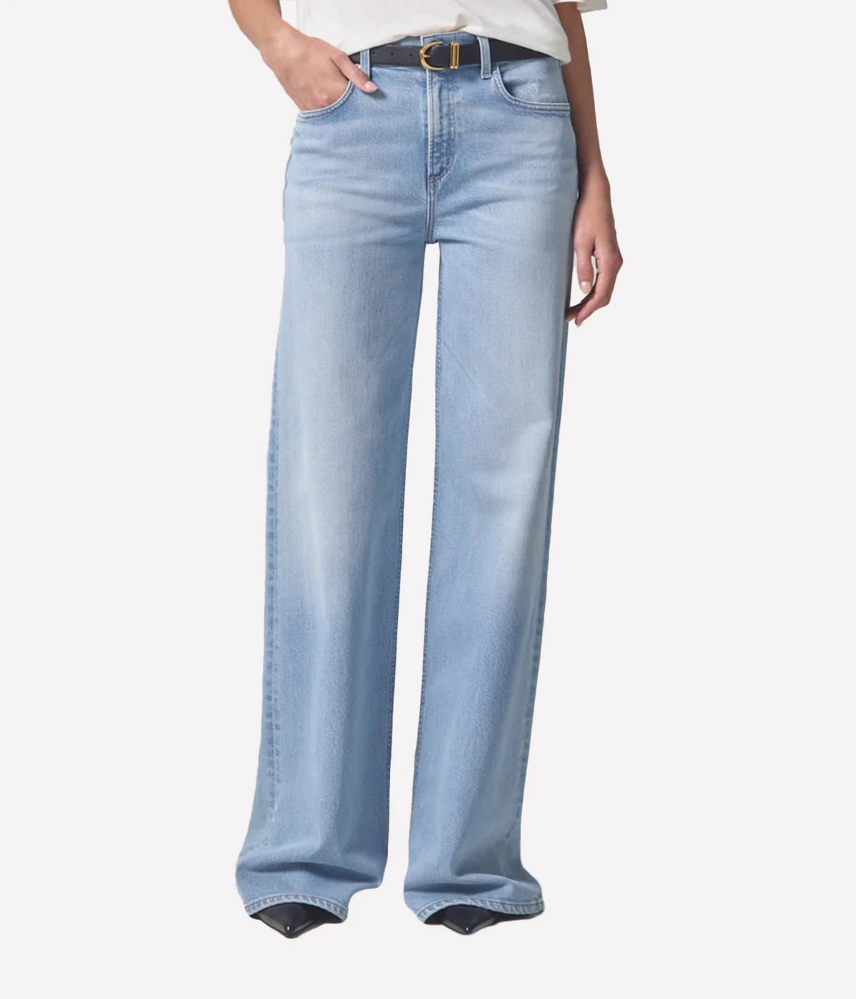 A pair of relaxed wide-leg jeans in a light wash, featuring a mid-rise waist, a 32” inseam, and a zip fly closure, styled to elongate the legs and provide a flattering silhouette.