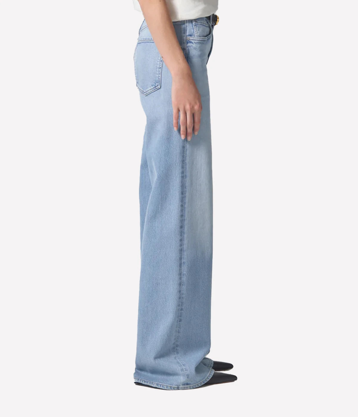A pair of relaxed wide-leg jeans in a light wash, featuring a mid-rise waist, a 32” inseam, and a zip fly closure, styled to elongate the legs and provide a flattering silhouette.