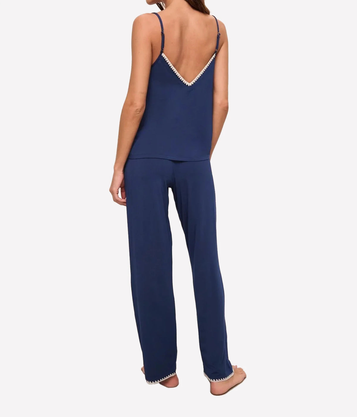 Back view of a model wearing the Eberjey Frida Cami Pant PJ Set In Navy & Ivory, showing the trimmed back neckline, fine straps and full-length pants