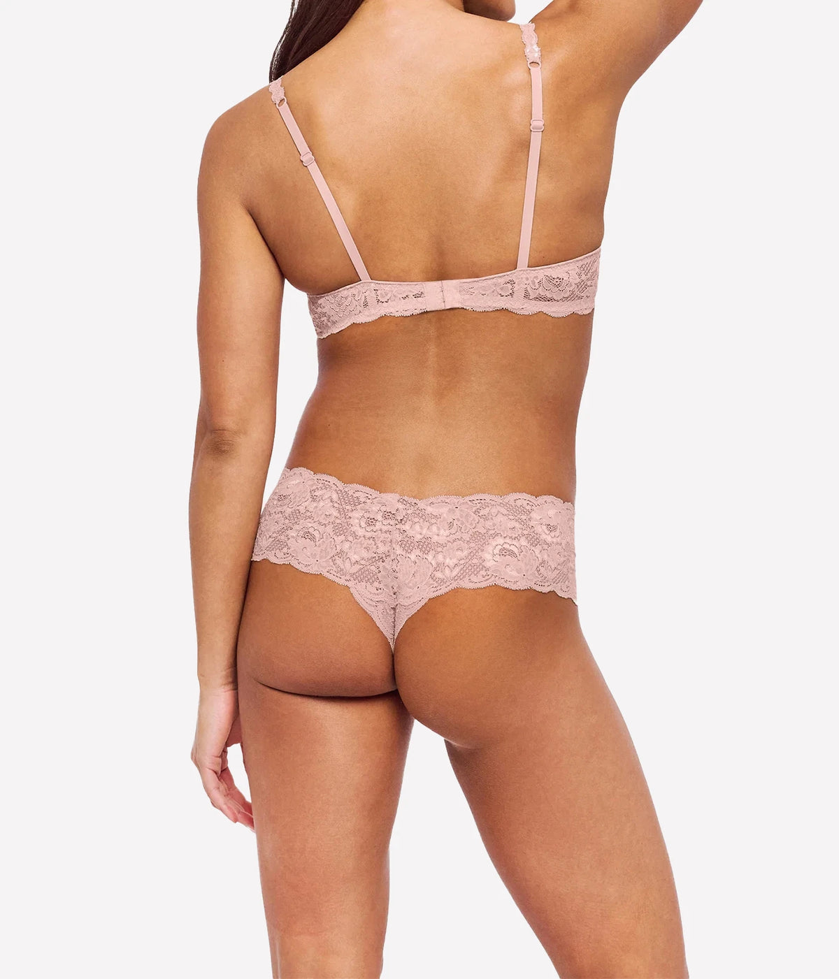 Back view of a model wearing the Cosabella NSN Balconette Bra in Mandorla with matching blush lace cheeky briefs, showing the back straps and band