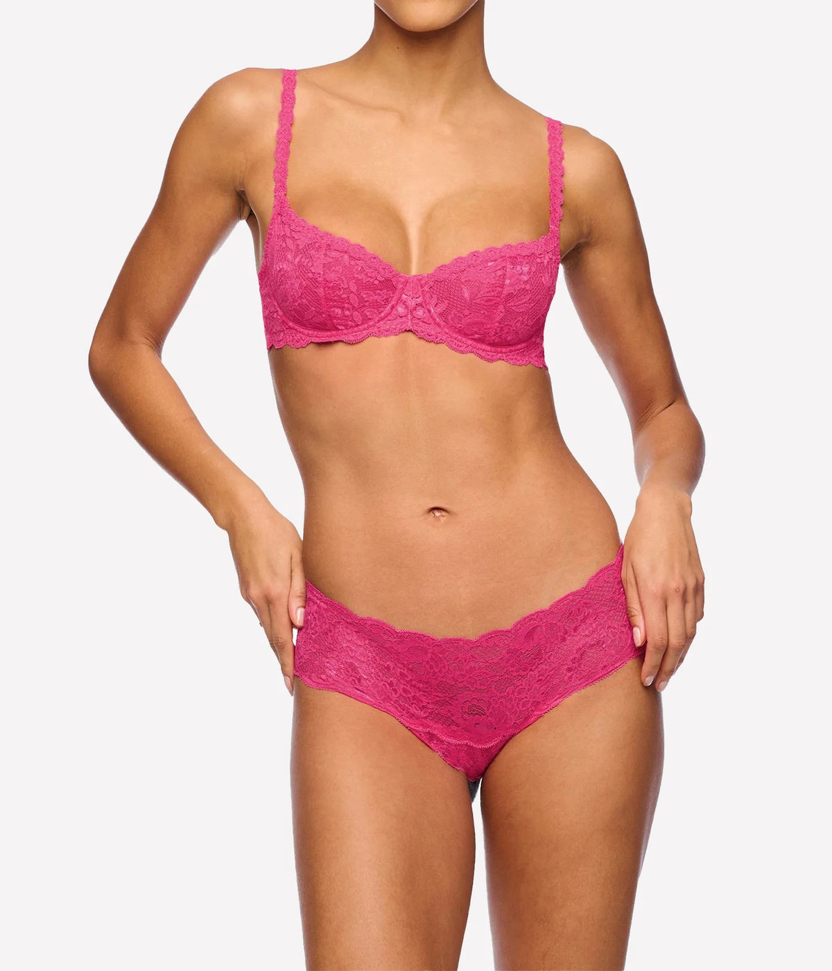 Model wearing the Cosabella NSN Balconette Bra in Rosa Caldo with matching hot pink lace hipster briefs, front view showing the all-over lace underwire cups and scalloped edges