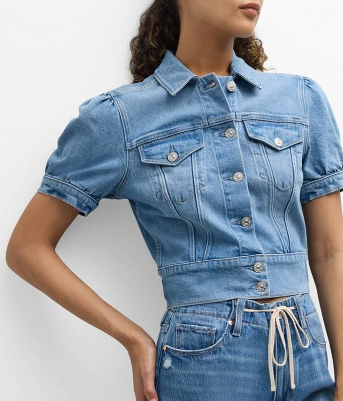 ALT text: Light wash denim jacket with puff sleeves, cropped fit, and chest pockets.