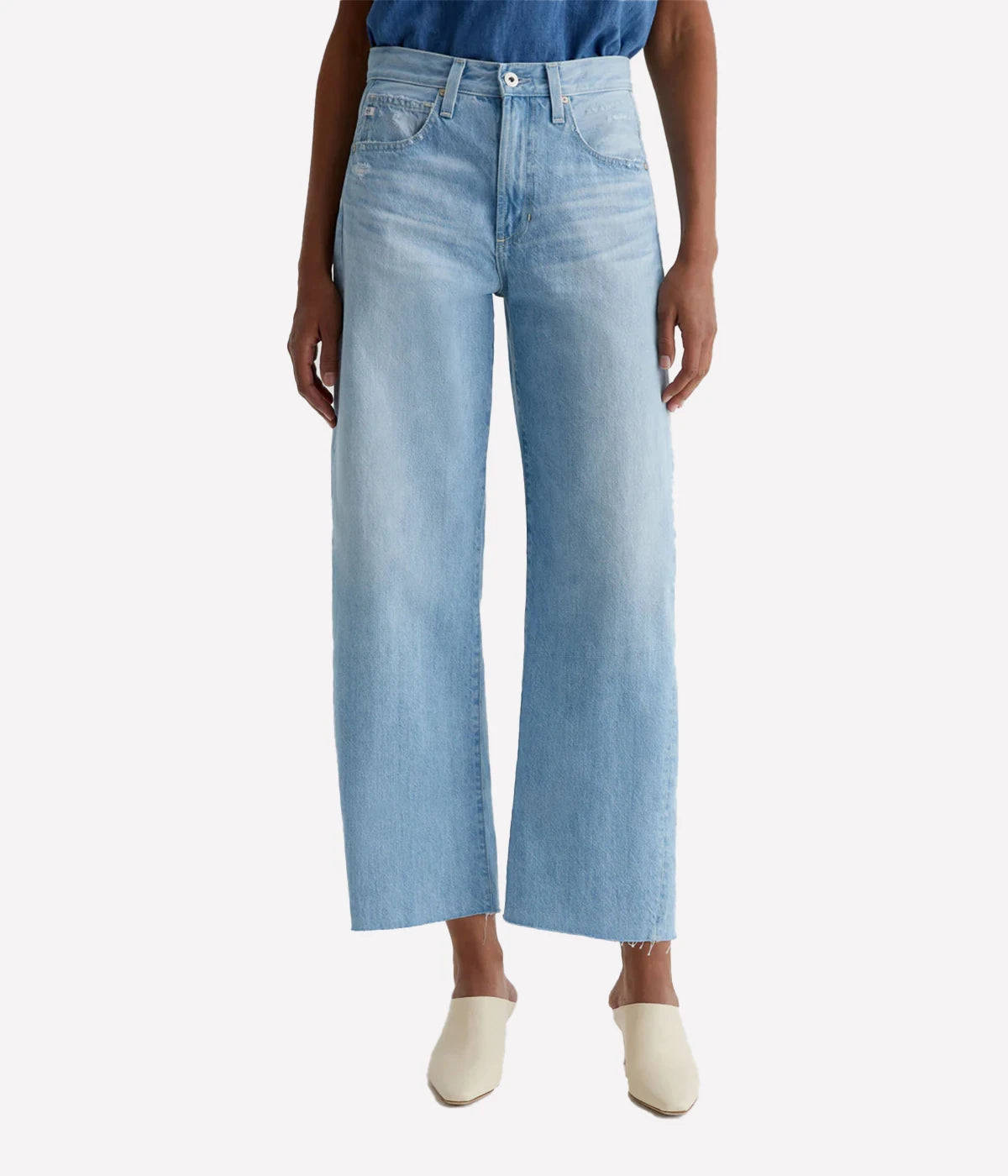 ALT text: Model wears mid-rise cotton denim jeans with fading, whiskering, and light distressing throughout