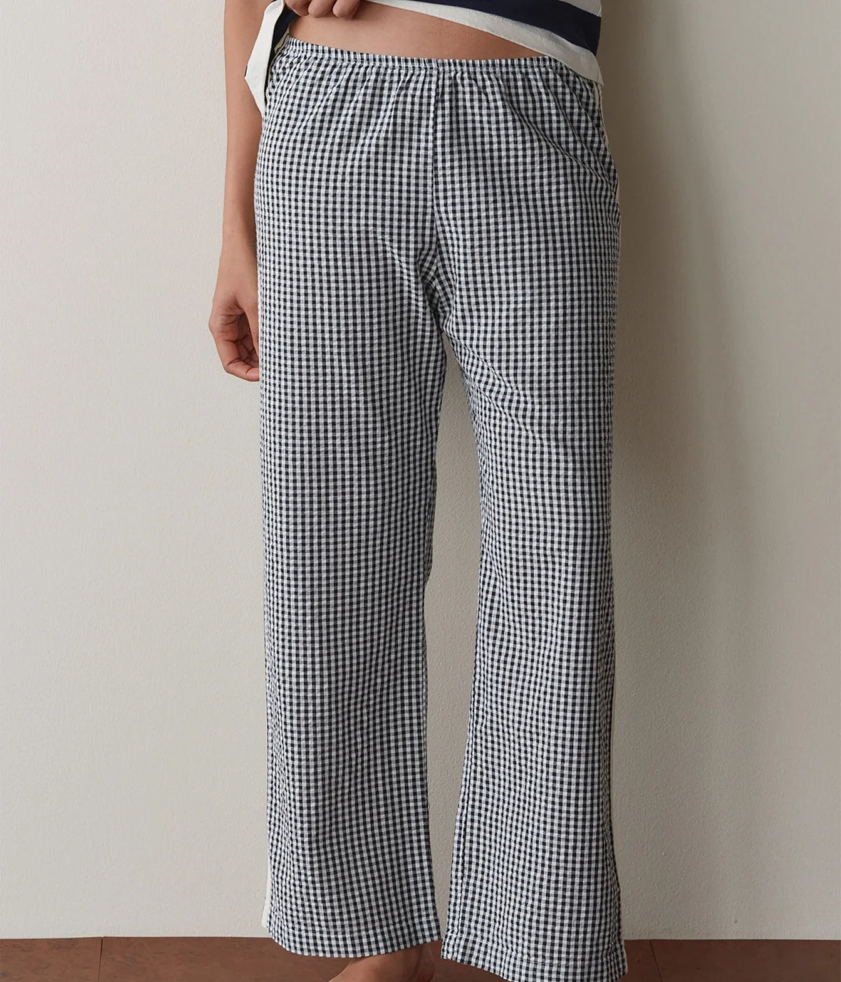 Model wearing navy gingham check pants, side profile view showing the straight-leg fit.