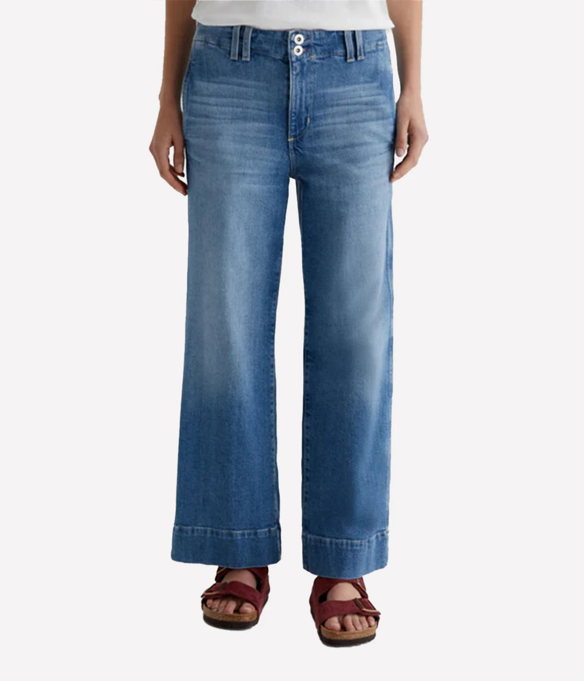 ALT text: Model wears AG Nastasha cropped wide-leg jeans in faded blue with mid-rise waist and utility-inspired front pockets