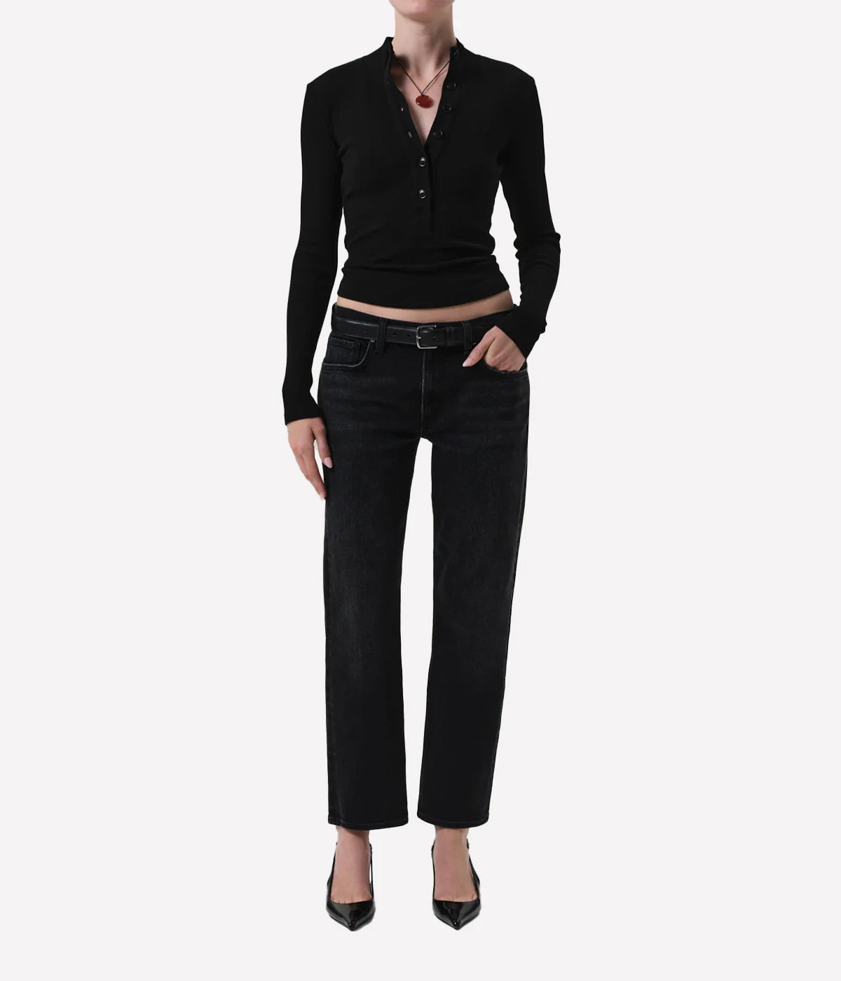 Person wearing a black long-sleeve top and black jeans on a white background