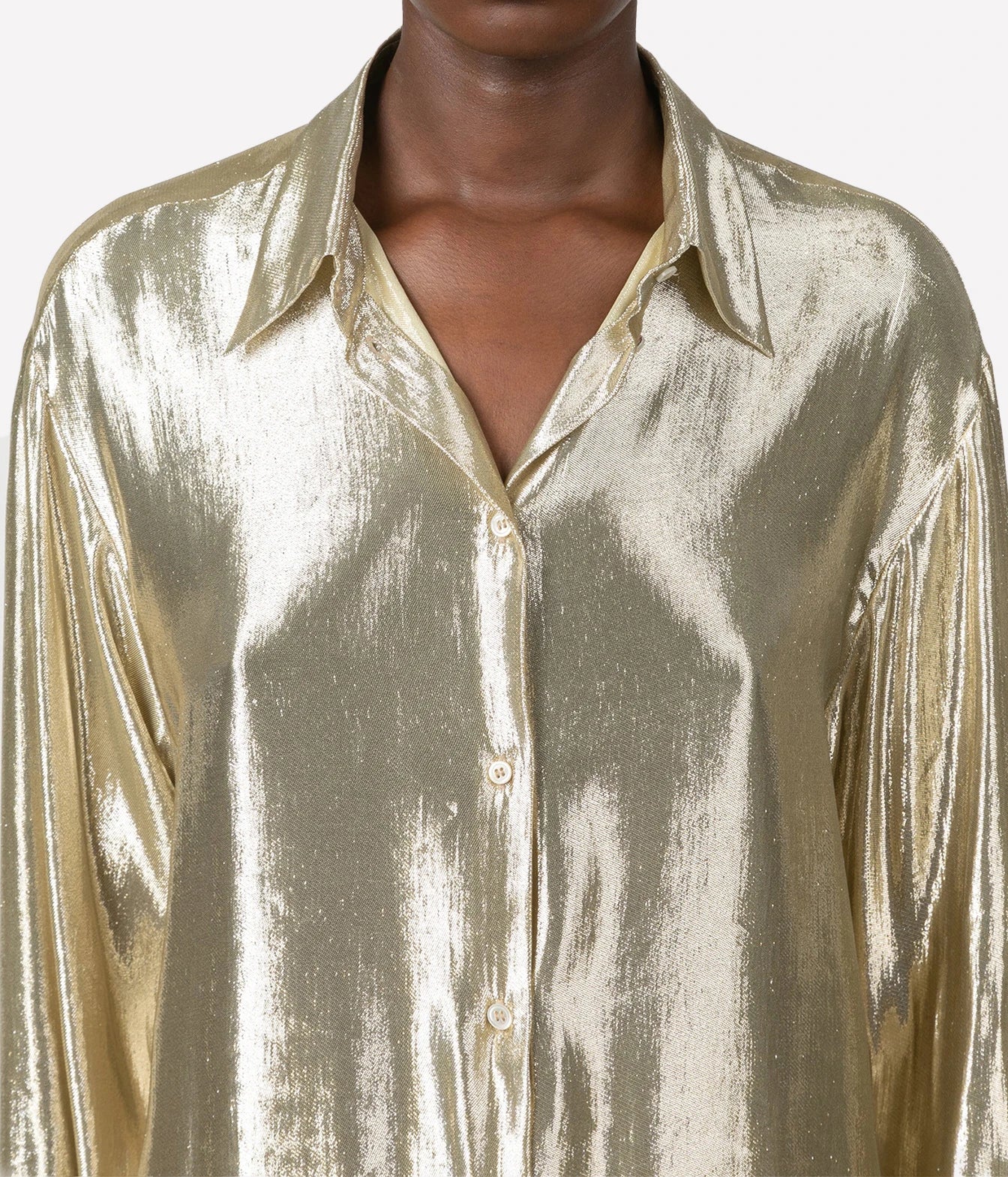 A close-up of a model wearing a metallic gold button-down shirt with a shiny, crinkled texture and a classic collar.